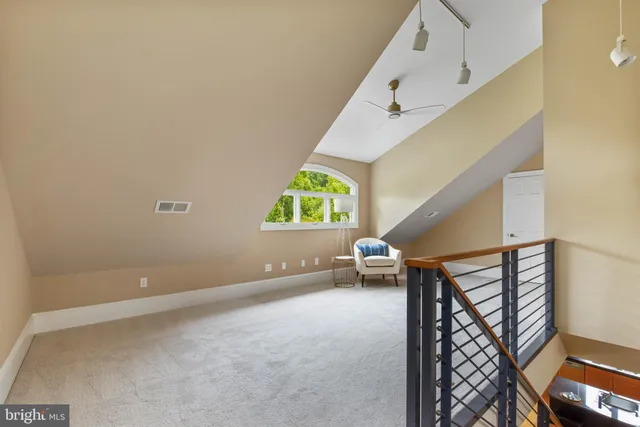 a bed sitting in a spacious bedroom next to a window
