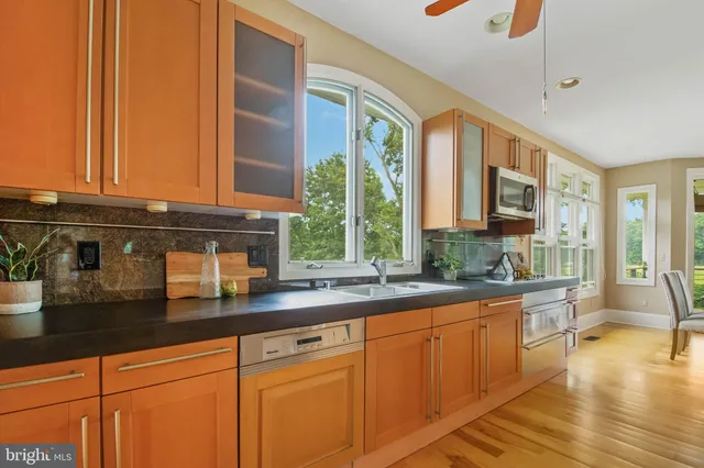 a kitchen with granite countertop a stove a sink and wooden cabinets