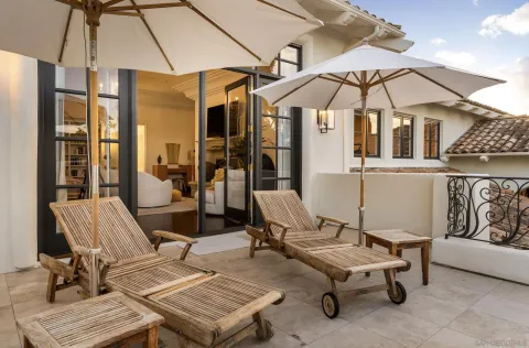 a view of a patio with a table and chairs under an umbrella