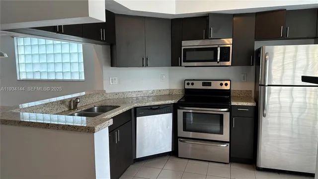 a kitchen with granite countertop a sink stove and refrigerator