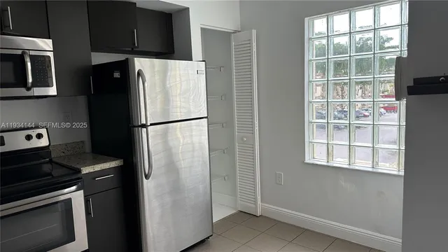 a white refrigerator freezer and a stove sitting inside of a kitchen