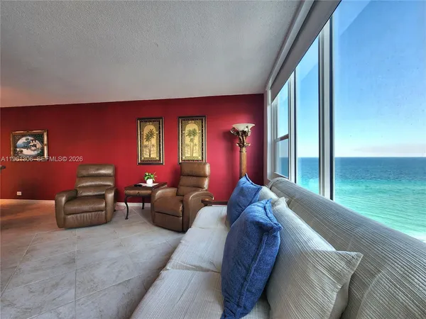 a living room with furniture and a floor to ceiling window