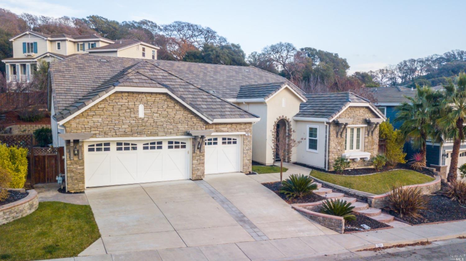 a view of a white house with a big yard and large trees