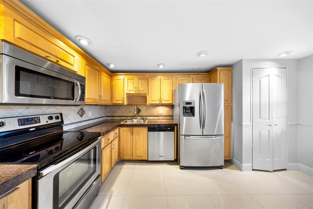 a kitchen with stainless steel appliances granite countertop a refrigerator a stove top oven a sink and dishwasher