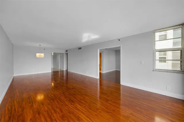 a view of empty room with wooden floor