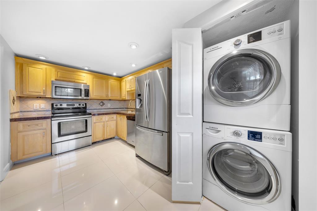 3520 Oaks Way, Unit 406 Pompano Beach, FL 33069 - Photo 2 of 32 a kitchen with cabinets and stainless steel appliances