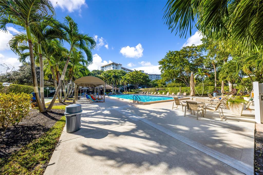 3520 Oaks Way, Unit 406 Pompano Beach, FL 33069 - Photo 31 of 32 a view of a patio with table and chairs and potted plants