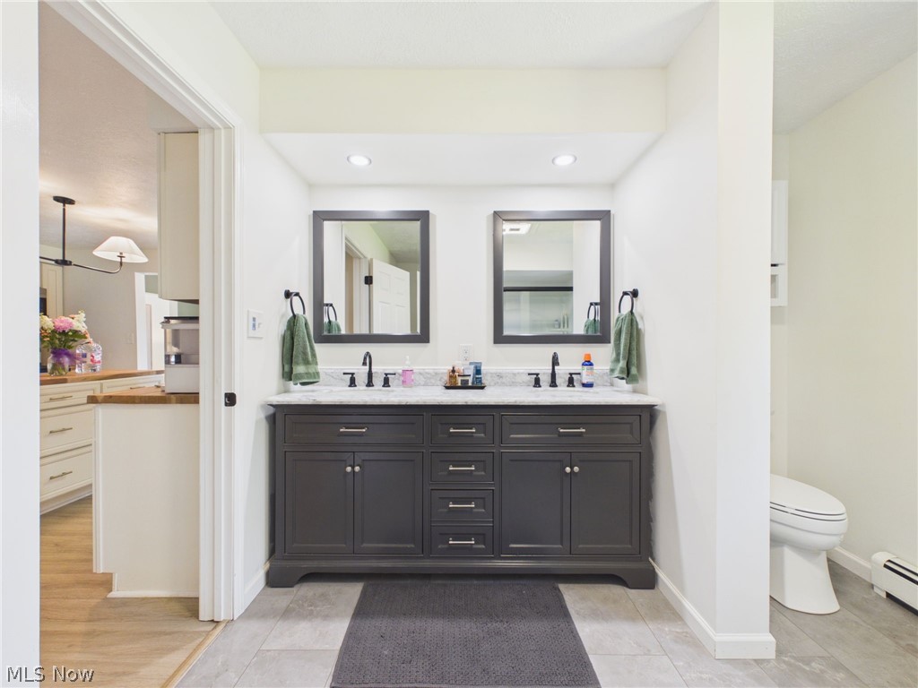 3490 County Line Road Madison, OH 44057 - Photo 8 of 42 Dual vanity with a stone countertop, featuring undermount sinks and matte black faucets