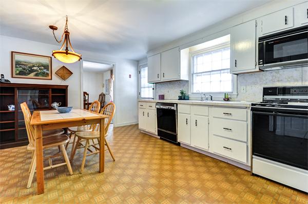 6 Hancock Road Needham, MA 02492 - Photo 6 of 19 a kitchen with stainless steel appliances a stove a sink a dining table and chairs