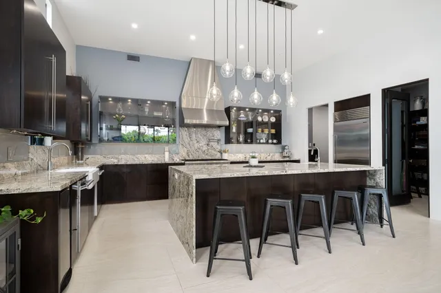 a kitchen with stainless steel appliances granite countertop a sink and a refrigerator