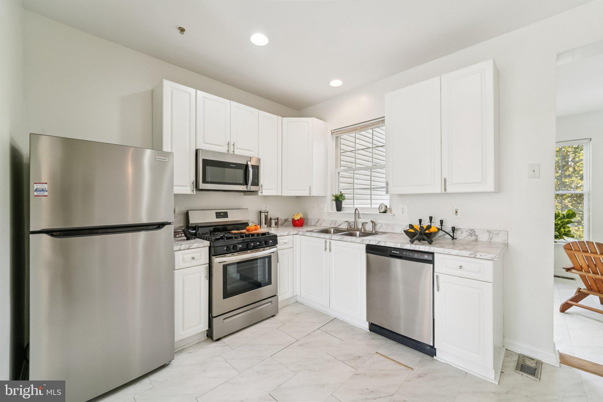 1007 Carbondale Way Crofton, MD 21114 - Photo 11 of 24 a kitchen with cabinets stainless steel appliances and a window