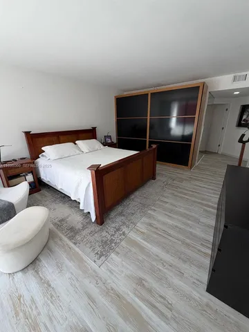 a bedroom with a bed furniture and a flat screen tv