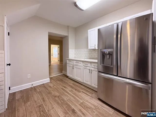 a kitchen with granite countertop stainless steel appliances a refrigerator and cabinets