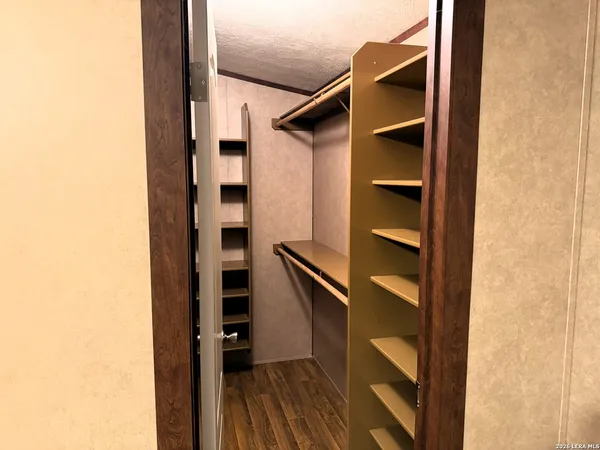 a view of walk in closet with empty racks