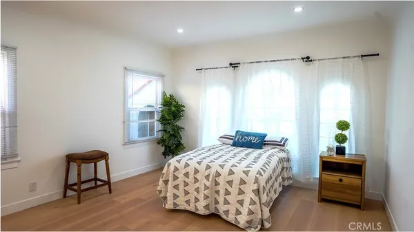 a bedroom with a bed table chair and a window
