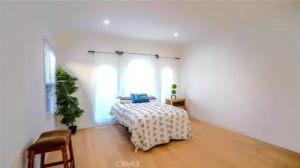 a bedroom with a bed plant and a window