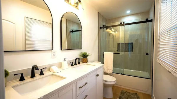 a bathroom with a double vanity sink toilet and shower