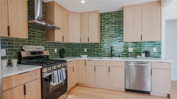 a kitchen with stainless steel appliances granite countertop a sink and a stove
