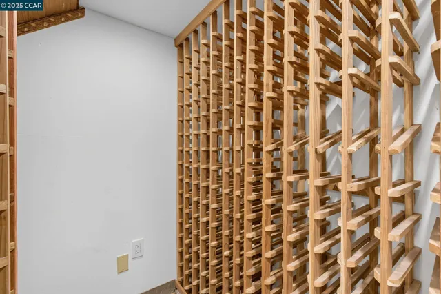 a bedroom with a bed a mirror and a large window with balcony view