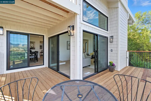 a living room with furniture kitchen view and a wooden floor
