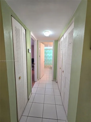a view of hallway with a large mirror and a shower