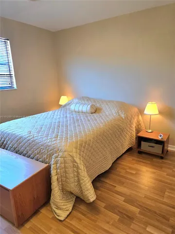 a bed sitting in a bedroom next to a lamp