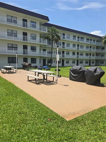a view of a building with garden and sitting area