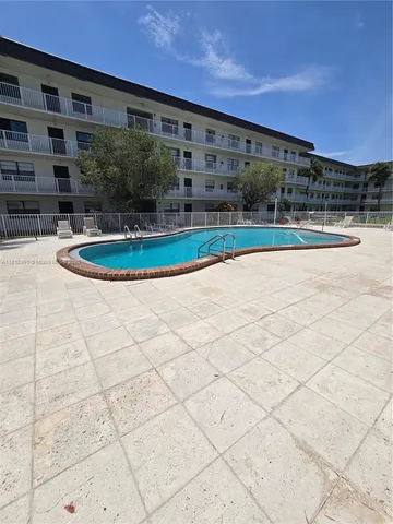 a view of a community park with multi story residential apartment building in the back
