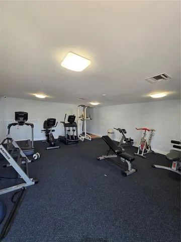 a living room with furniture gym equipment and a view of bedroom