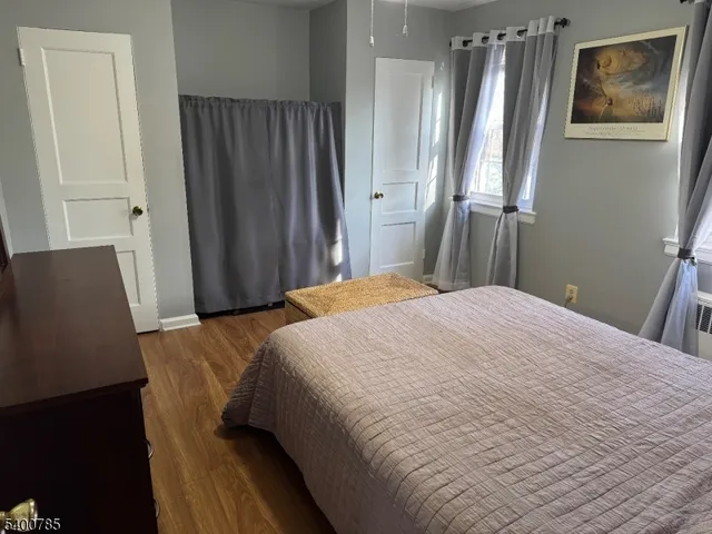 a bedroom with a bed and a refrigerator