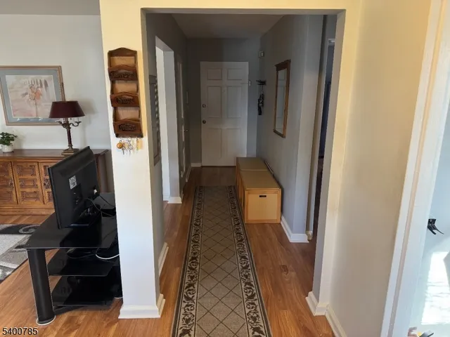 a walk in closet with wooden floor