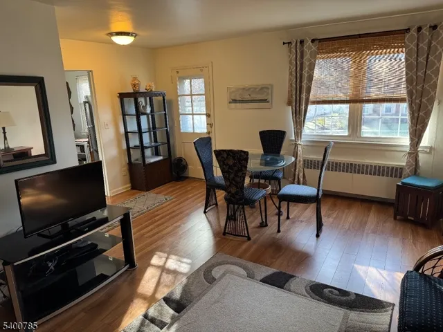 a living room with furniture a flat screen tv and a window