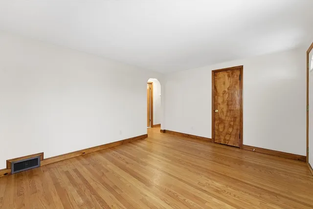 an empty room with wooden floor and a window