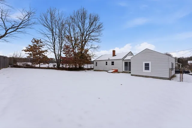a view of house with backyard and trees