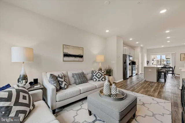 a kitchen with stainless steel appliances a sink dishwasher a stove top oven a refrigerator with wooden floor and cabinets