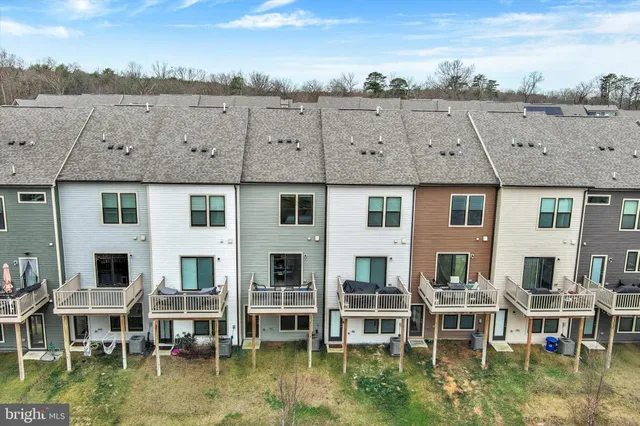 a front view of a house with a garden and lake view