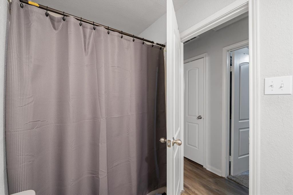 123 Harmon Road Gun Barrel City, TX 75156 - Photo 26 of 36 a view of a bathroom with a shower curtain and a window