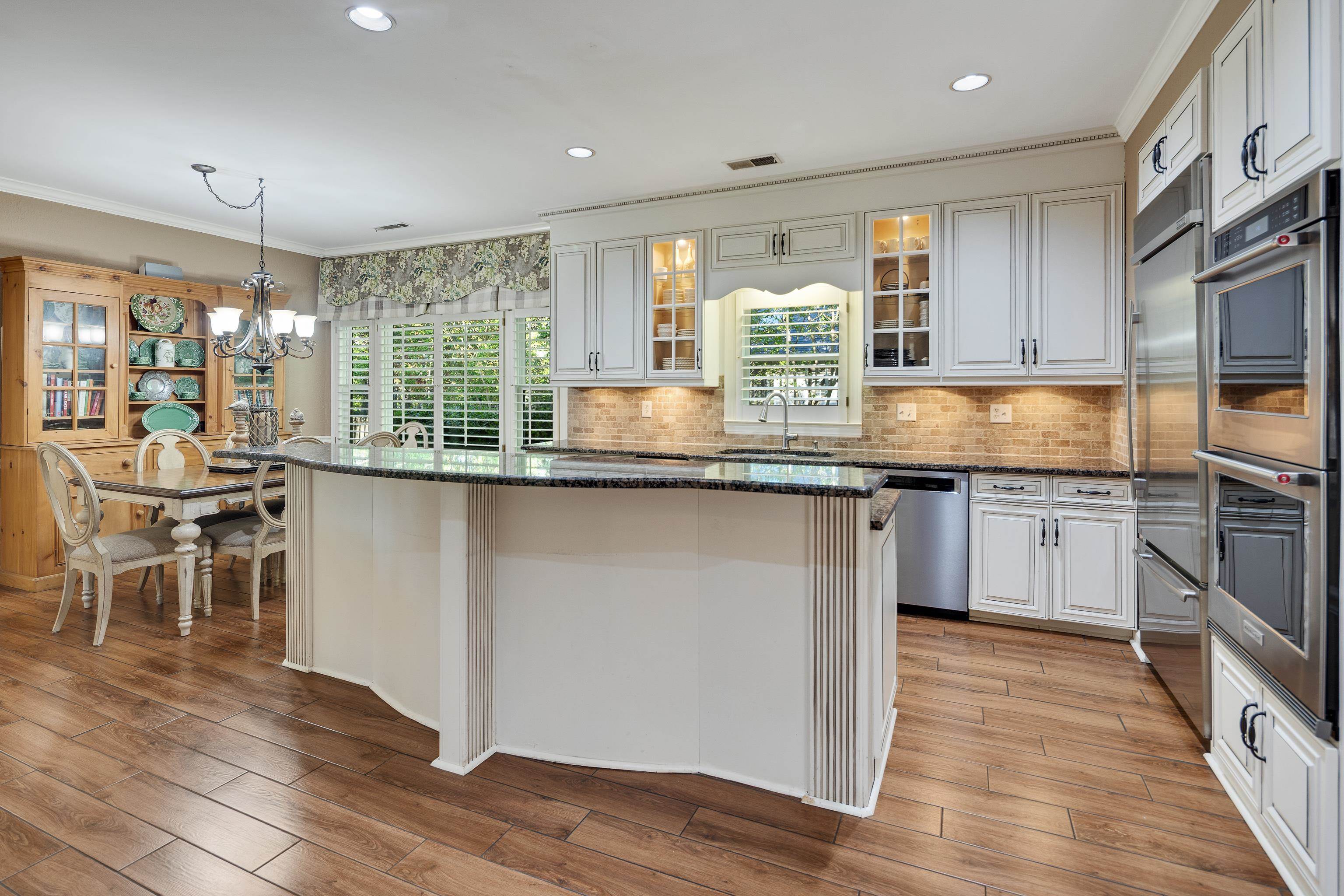 6326 East Shady Grove Road Memphis, TN 38120 - Photo 12 of 40 a kitchen with granite countertop kitchen island wooden floor center island and stainless steel appliances