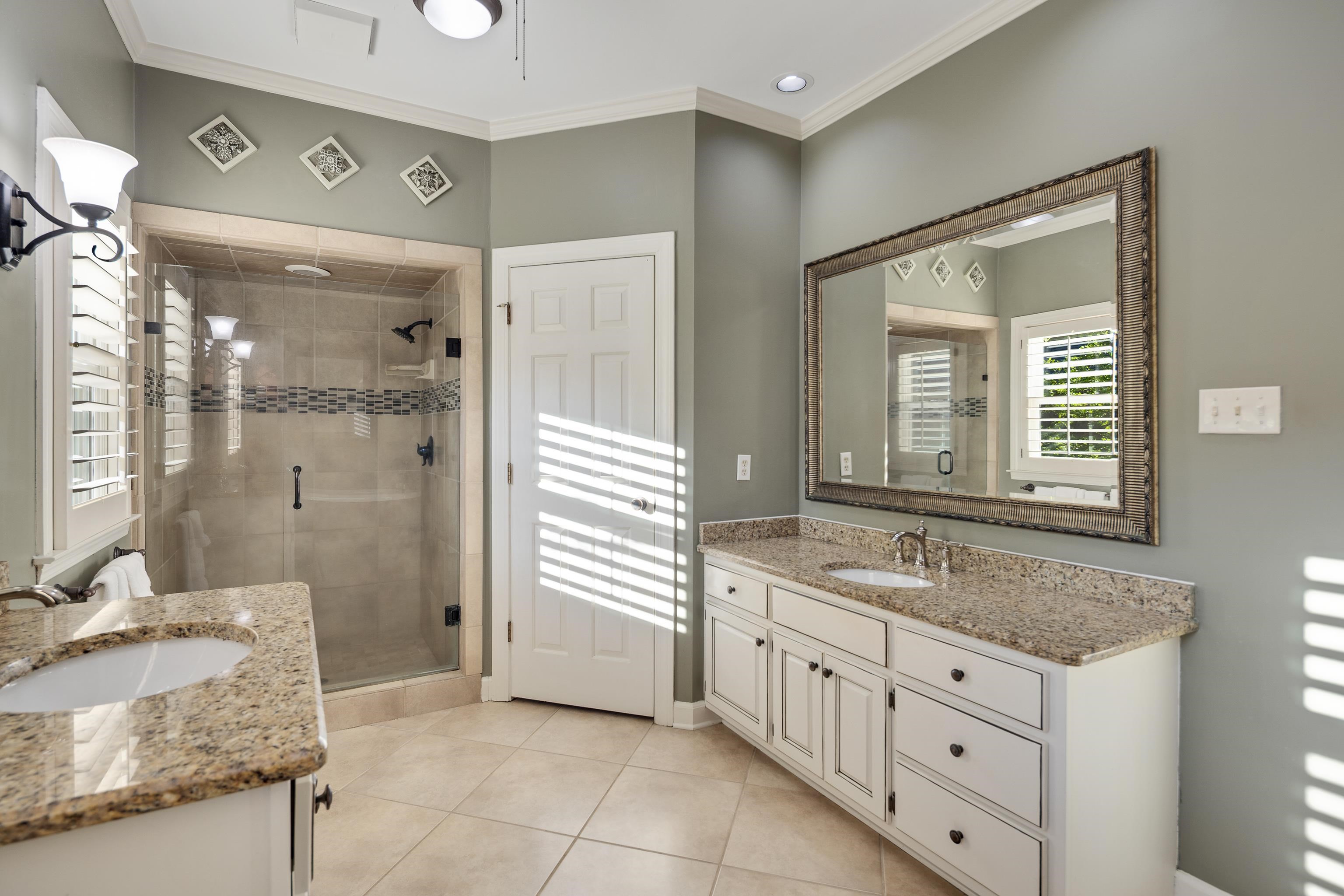 6326 East Shady Grove Road Memphis, TN 38120 - Photo 18 of 40 a bathroom with a granite countertop sink a mirror and a shower
