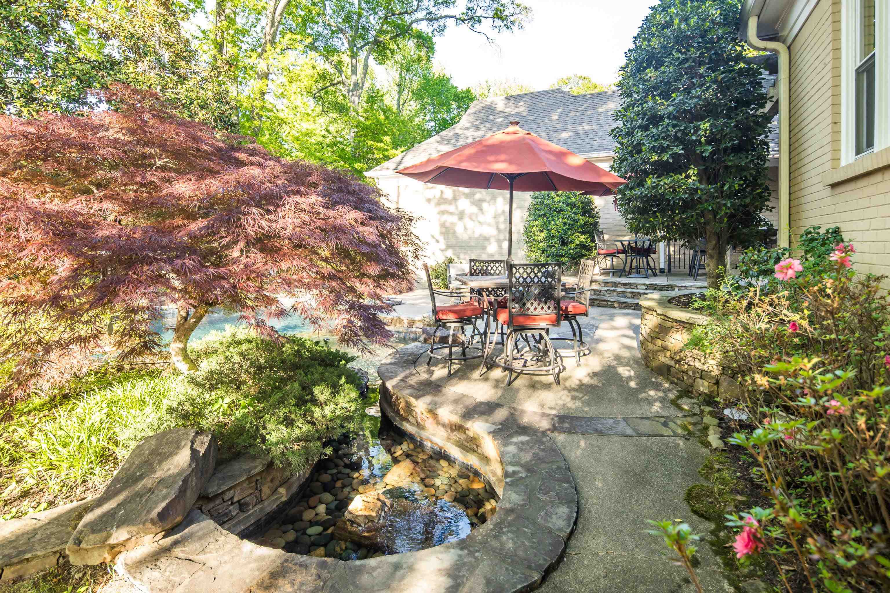6326 East Shady Grove Road Memphis, TN 38120 - Photo 38 of 40 a view of a patio with chairs and a table and chairs under an umbrella