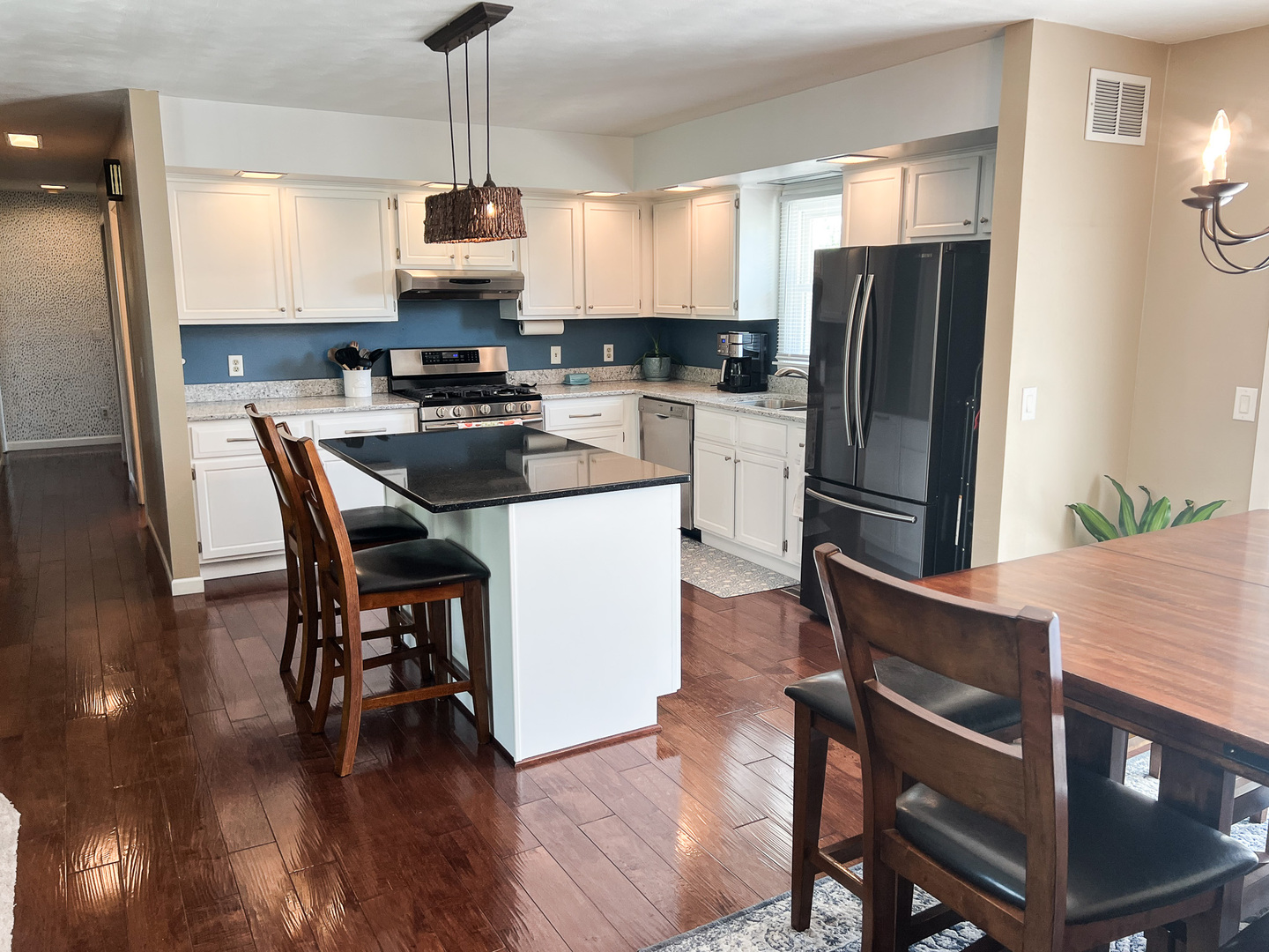 2201 Oak Drive Eureka, IL 61530 - Photo 20 of 25 a kitchen with stainless steel appliances granite countertop a stove a refrigerator a microwave a dining table and chairs with wooden floor