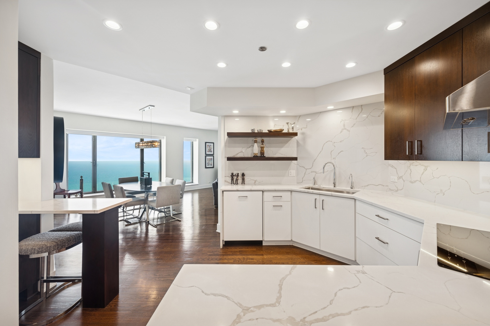 950 North Michigan Avenue, Unit 3705 Chicago, IL 60611 - Photo 15 of 47 a large white kitchen with lots of counter space dining table and chairs