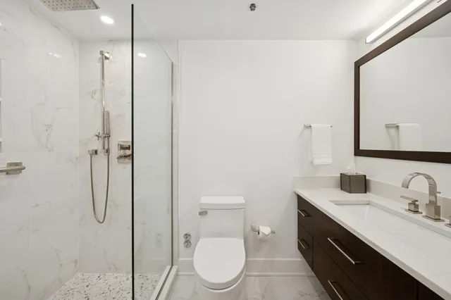 a bathroom with a toilet sink shower and mirror