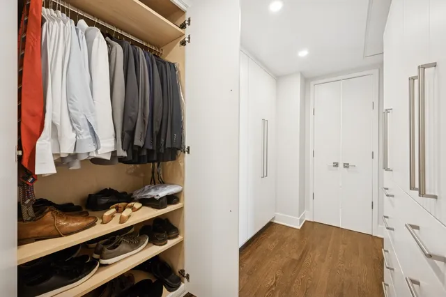 a view of walk in closet with clothes and shoes