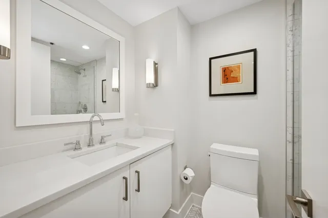 a bathroom with a toilet sink and mirror