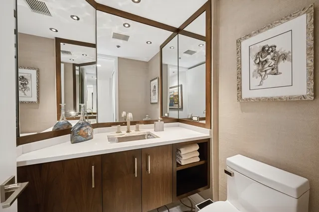 a bathroom with a sink vanity mirror and toilet