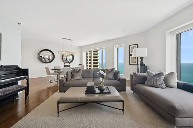 a living room with furniture a clock on wall and a window
