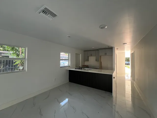a large kitchen with kitchen island granite countertop a sink and dishwasher with a large window