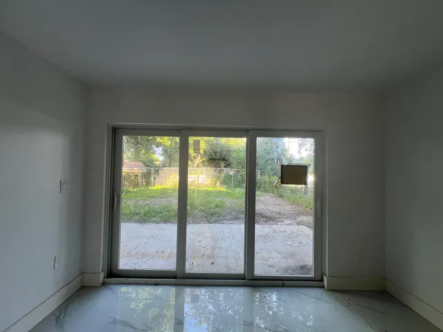 a view of an empty room with large windows