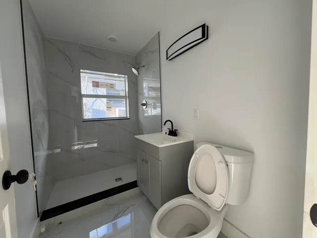 a bathroom with a toilet sink and mirror